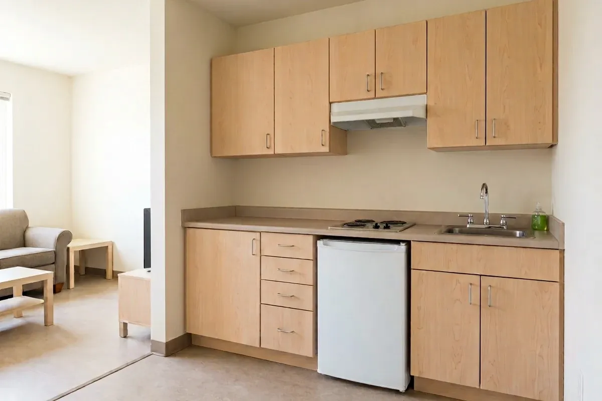 A tiny apartment kitchen with one cleared food-preparation surface and limited storage
